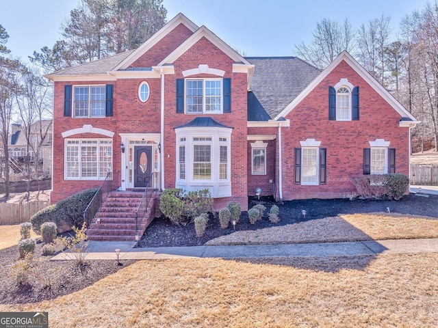 view of front of house with brick siding and fence