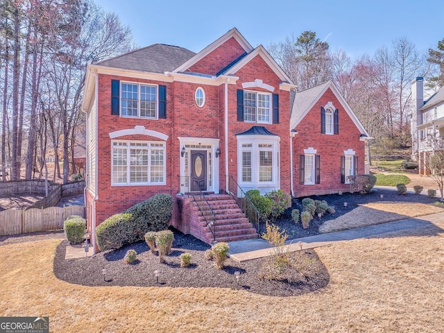 view of front of property featuring brick siding and fence