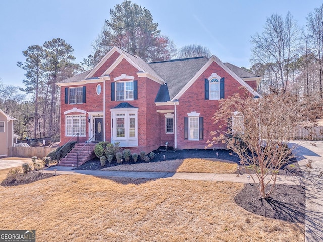 view of front of house with a front yard and brick siding