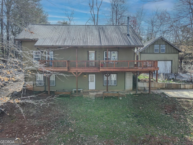 rear view of property with a deck, metal roof, and an outdoor structure