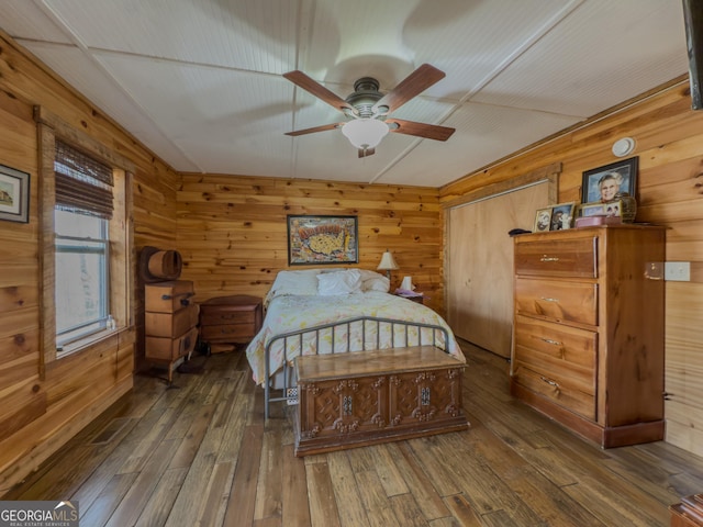 bedroom with hardwood / wood-style flooring and wooden walls