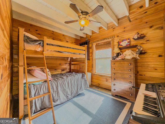 bedroom with carpet floors, wood walls, and beamed ceiling