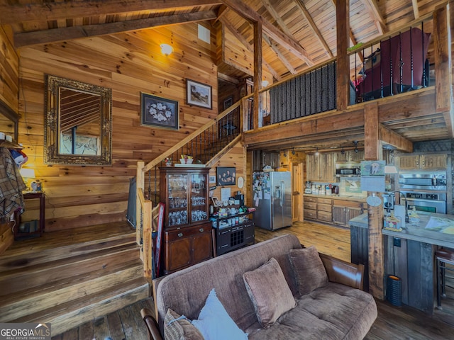 living room with wood walls, stairs, high vaulted ceiling, wood-type flooring, and beamed ceiling