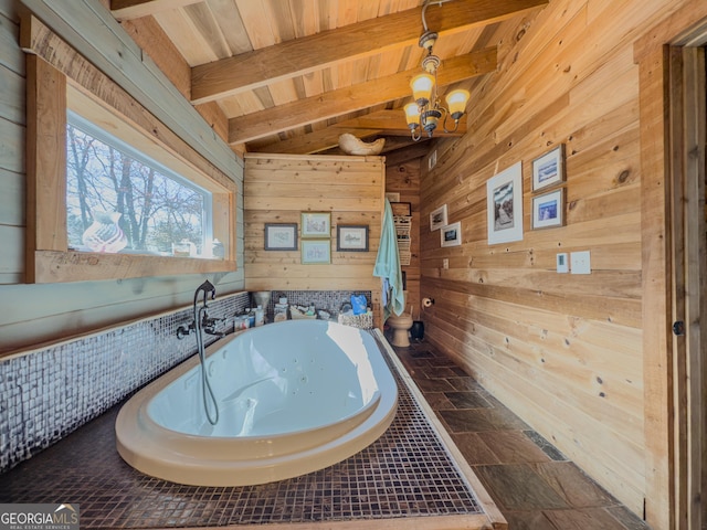 full bathroom with wooden ceiling, wooden walls, a jetted tub, beam ceiling, and stone finish floor