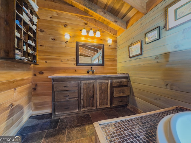 bathroom featuring wood ceiling, stone finish floor, vaulted ceiling with beams, wooden walls, and vanity