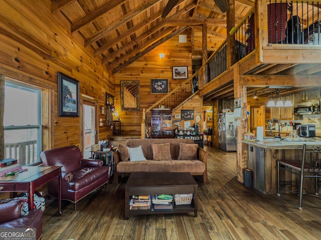 living room featuring wood-type flooring, wood walls, stairway, and high vaulted ceiling