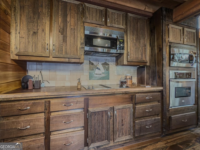 kitchen with appliances with stainless steel finishes, dark brown cabinets, and decorative backsplash