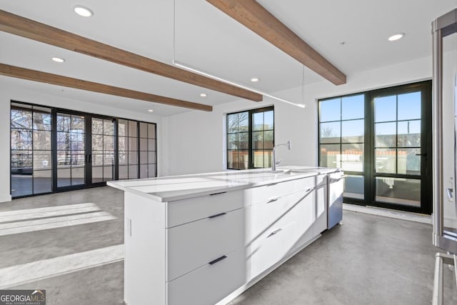 kitchen with recessed lighting, white cabinets, finished concrete flooring, beamed ceiling, and modern cabinets