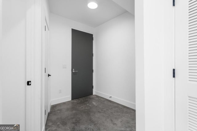 unfurnished bedroom featuring concrete floors and baseboards