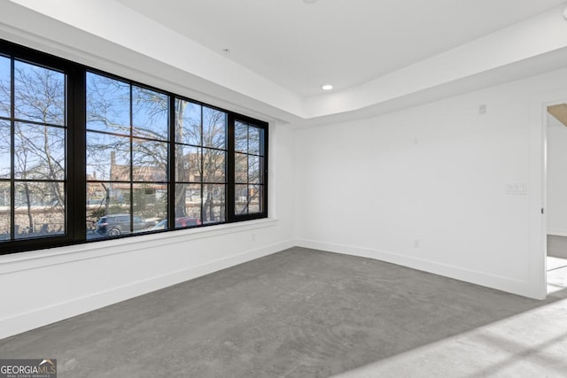 spare room with concrete floors, baseboards, and recessed lighting