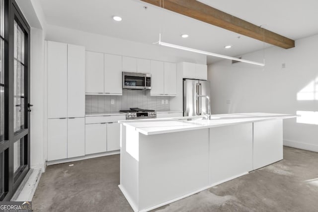 kitchen with stainless steel appliances, concrete floors, and white cabinets