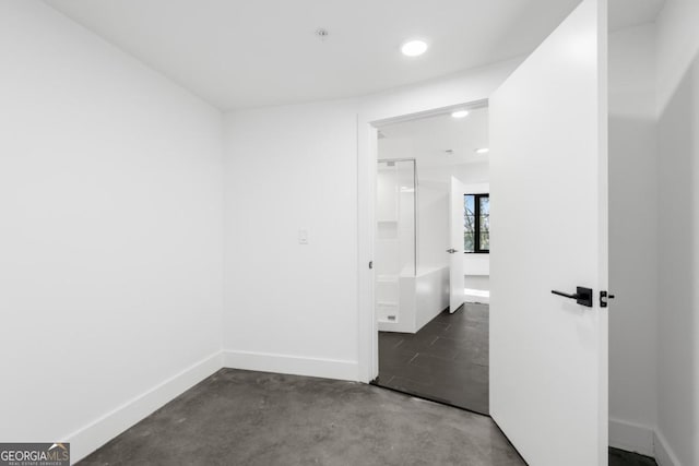 unfurnished bedroom featuring recessed lighting, concrete floors, and baseboards