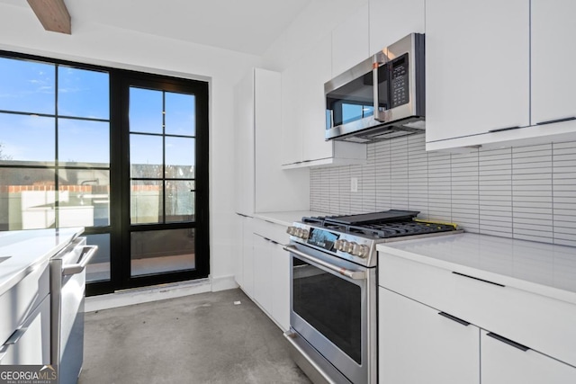 kitchen featuring appliances with stainless steel finishes, white cabinets, light countertops, and tasteful backsplash