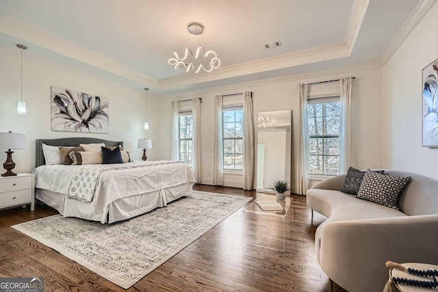 bedroom featuring ornamental molding, a tray ceiling, dark wood-type flooring, and visible vents