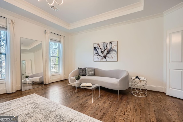 sitting room featuring a tray ceiling, wood finished floors, visible vents, and crown molding