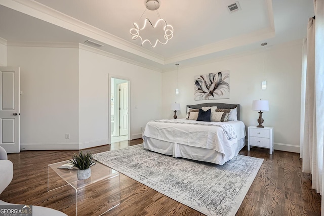 bedroom featuring visible vents, dark wood finished floors, baseboards, a tray ceiling, and crown molding