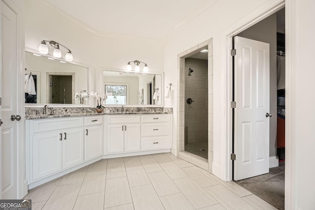 full bathroom featuring double vanity, a sink, and a shower stall