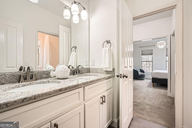 bathroom with a sink, ensuite bath, and double vanity