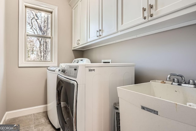 laundry room with cabinet space, a sink, baseboards, and separate washer and dryer