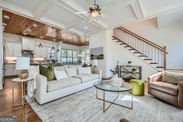 living area featuring stairs, coffered ceiling, wood finished floors, and wood ceiling