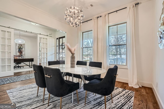 dining area featuring baseboards, visible vents, wood finished floors, french doors, and a notable chandelier