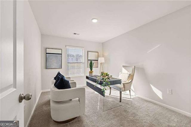 sitting room with carpet flooring, visible vents, and baseboards