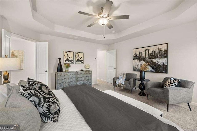 bedroom featuring carpet floors, baseboards, a raised ceiling, and a ceiling fan