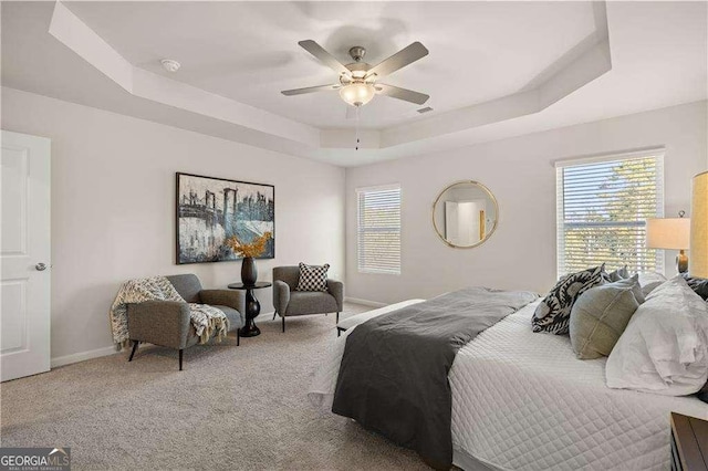 bedroom with carpet floors, a raised ceiling, ceiling fan, and baseboards