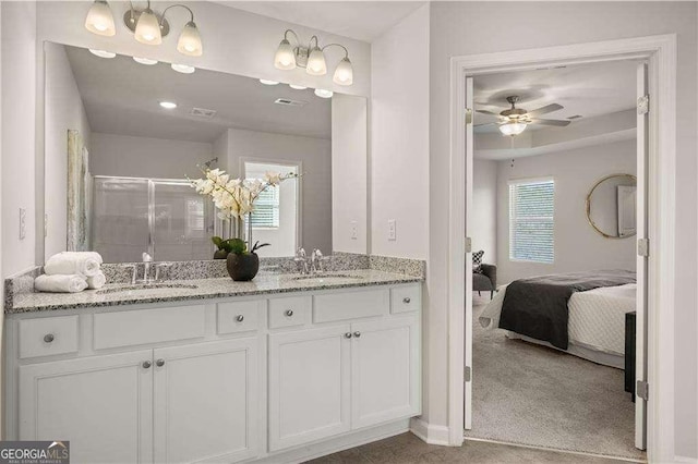 ensuite bathroom featuring double vanity, a stall shower, a sink, and visible vents