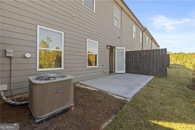 back of house featuring central AC, a patio, a lawn, and fence