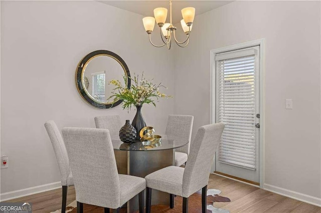 dining room featuring a notable chandelier, baseboards, and wood finished floors