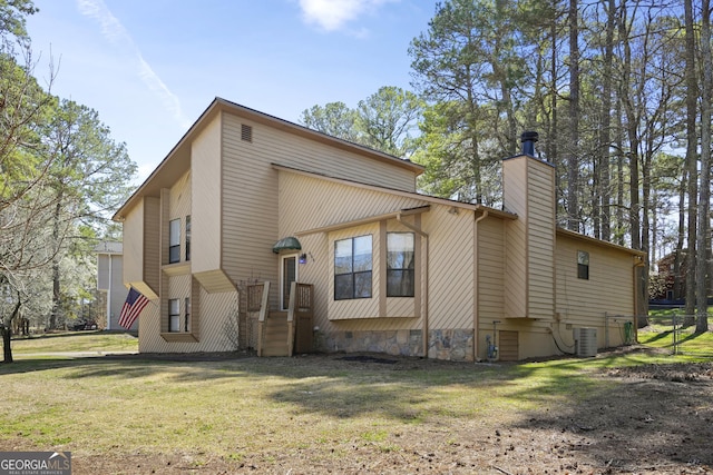 back of house featuring a lawn, a chimney, central AC, and crawl space