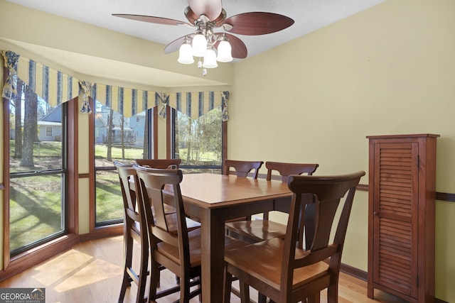 dining space featuring baseboards and light wood-style flooring