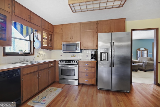 kitchen featuring a sink, tasteful backsplash, appliances with stainless steel finishes, and light countertops