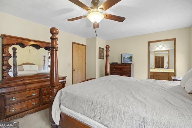 bedroom featuring a textured ceiling, ensuite bathroom, a ceiling fan, and carpet floors