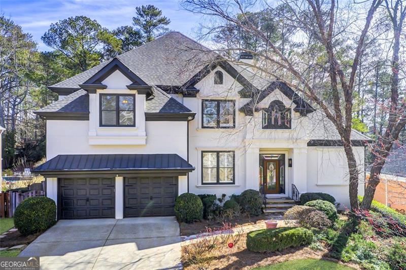 french country style house with driveway, a garage, a shingled roof, metal roof, and a standing seam roof