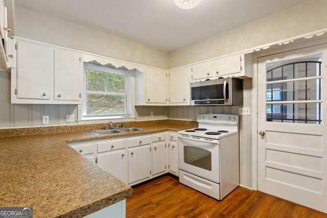 kitchen with electric stove, dark wood finished floors, stainless steel microwave, white cabinetry, and a sink