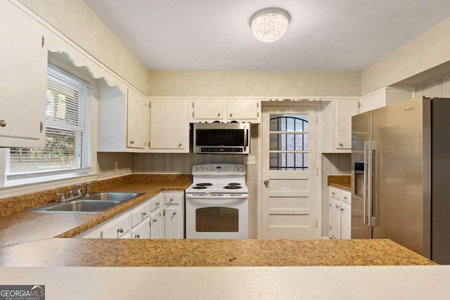 kitchen featuring appliances with stainless steel finishes, white cabinetry, and a sink