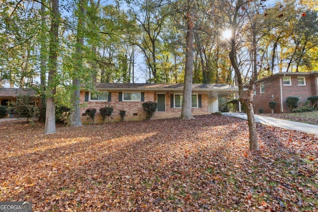 single story home with an attached carport, crawl space, brick siding, and driveway