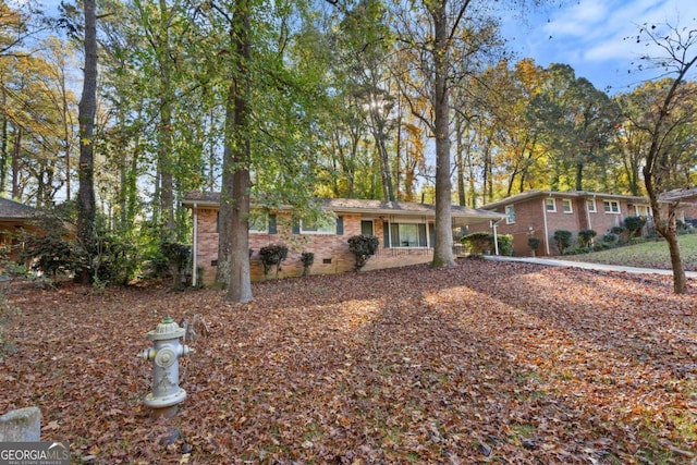 view of front of home with brick siding and crawl space