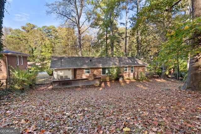 back of house with brick siding and a wooden deck