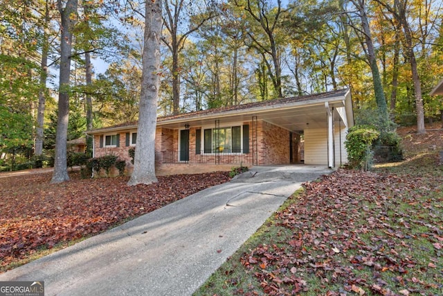 ranch-style house with concrete driveway, brick siding, and an attached carport