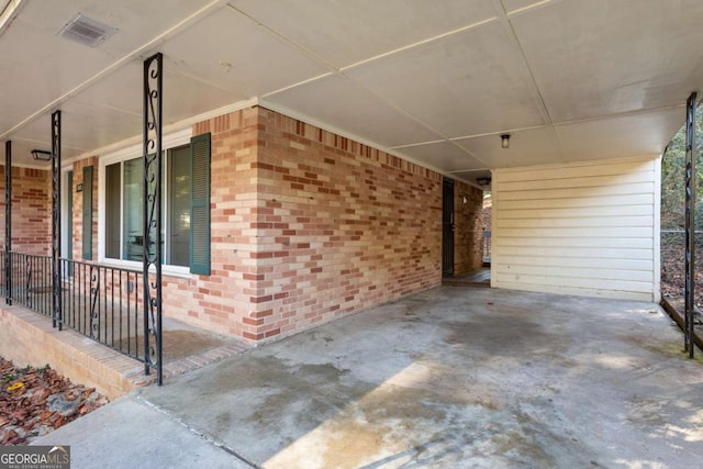 view of patio with covered porch, a carport, driveway, and visible vents