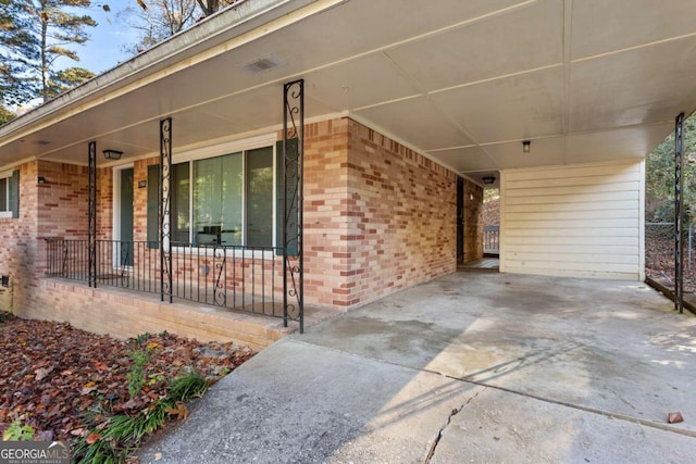 view of patio featuring covered porch, an attached carport, and concrete driveway