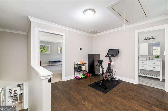 workout area with attic access, ornamental molding, and wood finished floors