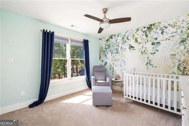 bedroom featuring a crib, carpet, a ceiling fan, and baseboards