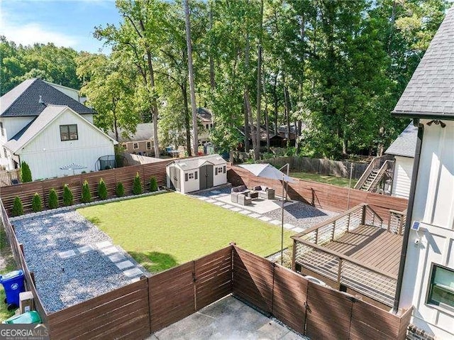 view of yard with an outbuilding, a patio, a fenced backyard, a storage shed, and stairway