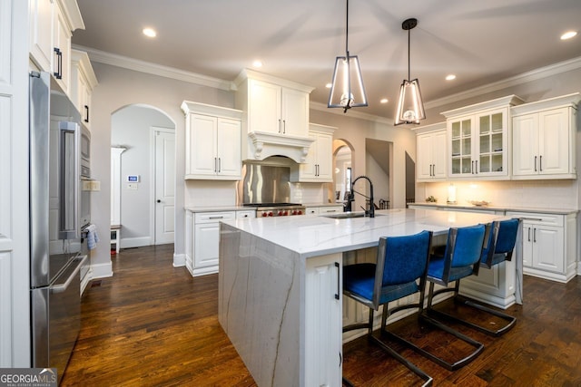 5230 Harris Springs Dr, Cumming, GA 30040 - kitchen featuring a sink, arched walkways, a kitchen island with sink, recessed lighting, and tasteful backsplash