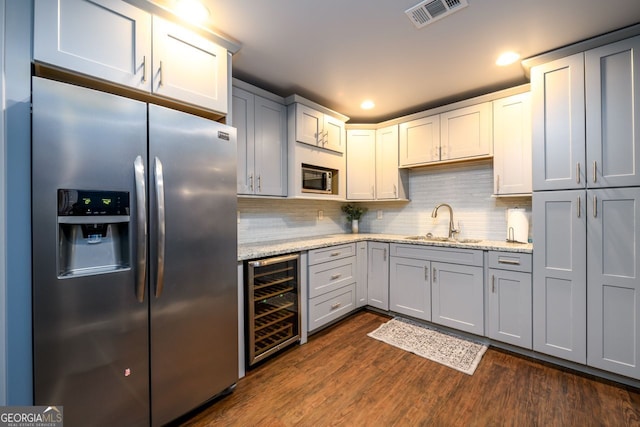 5230 Harris Springs Dr, Cumming, GA 30040 - kitchen with stainless steel appliances, wine cooler, a sink, dark wood-style flooring, and decorative backsplash