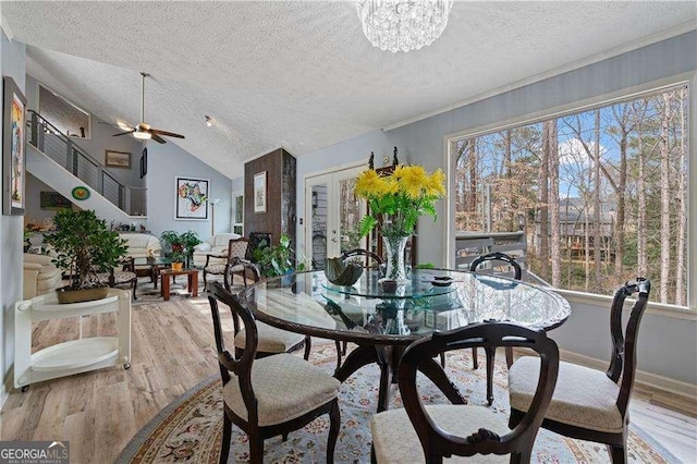 dining room with plenty of natural light, vaulted ceiling, french doors, and light wood-style flooring